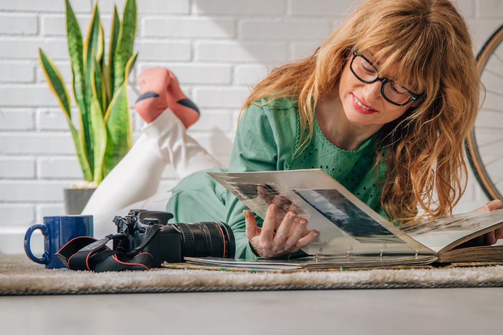 Frau blättert in einem Fotoalbum — Erinnerungen greifbar machen.